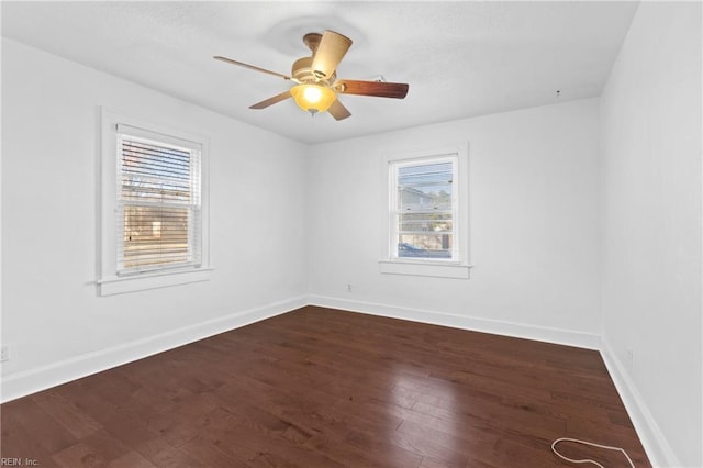 spare room featuring plenty of natural light, dark hardwood / wood-style floors, and ceiling fan