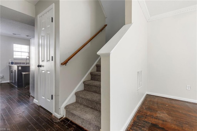 stairs with hardwood / wood-style flooring, sink, and a textured ceiling