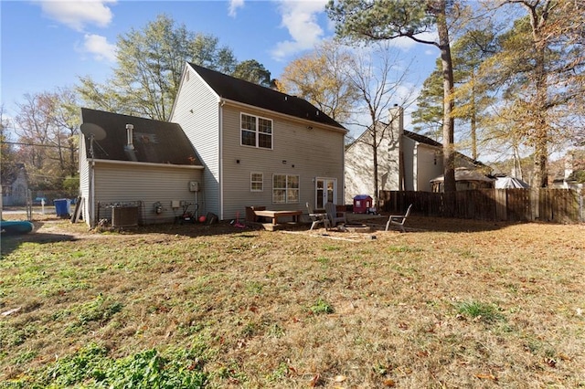 back of house featuring a lawn and central AC