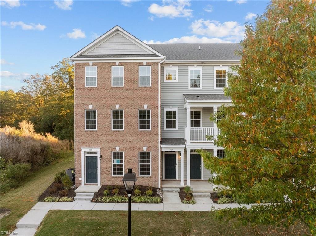 view of front of home featuring a balcony and a front yard