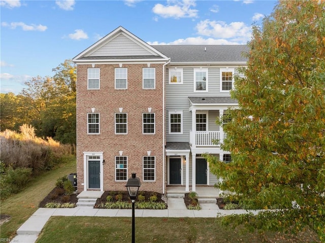 view of front of home featuring a balcony and a front yard