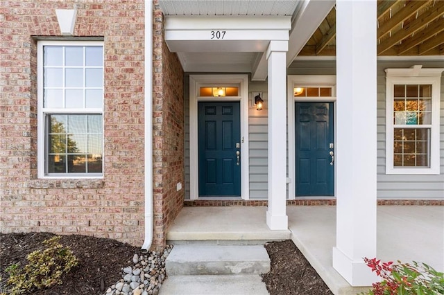 view of exterior entry featuring covered porch