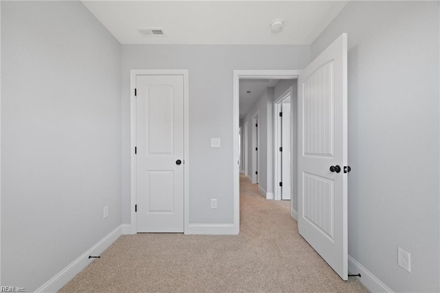 unfurnished bedroom featuring light carpet