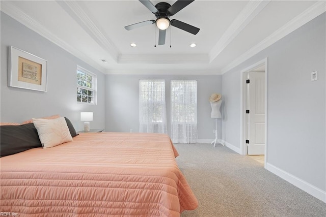 carpeted bedroom with ceiling fan, crown molding, and a tray ceiling