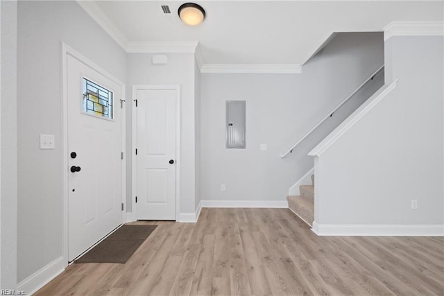 foyer entrance with electric panel, crown molding, and light hardwood / wood-style floors