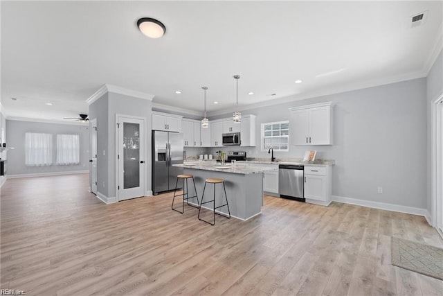 kitchen with ceiling fan, a center island, light hardwood / wood-style floors, white cabinets, and appliances with stainless steel finishes