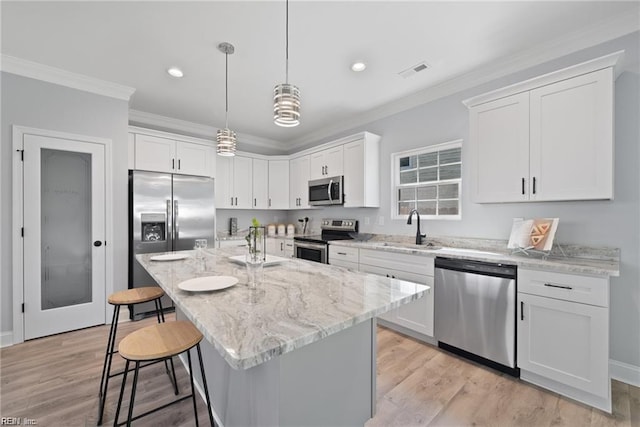 kitchen with white cabinetry, a center island, stainless steel appliances, and sink