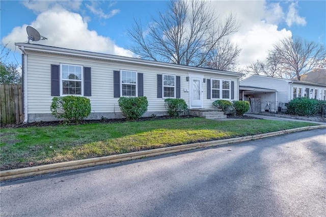 ranch-style home featuring a front lawn and a carport