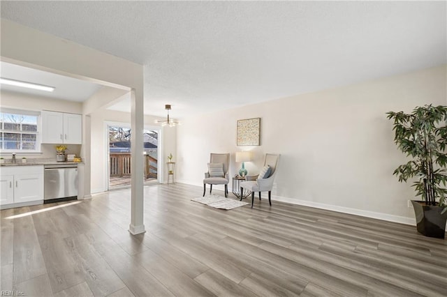 sitting room featuring an inviting chandelier, sink, and light hardwood / wood-style flooring