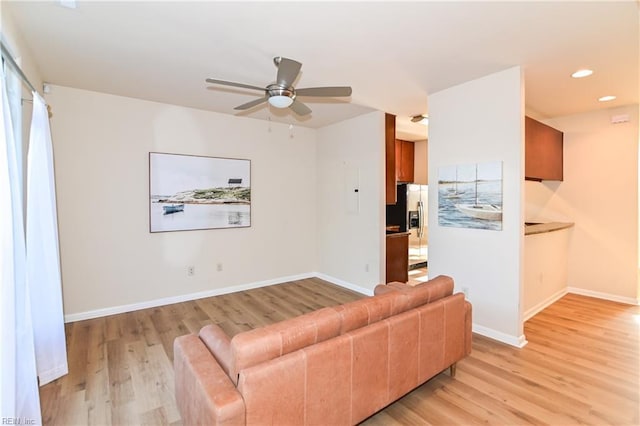 unfurnished living room featuring ceiling fan and light wood-type flooring