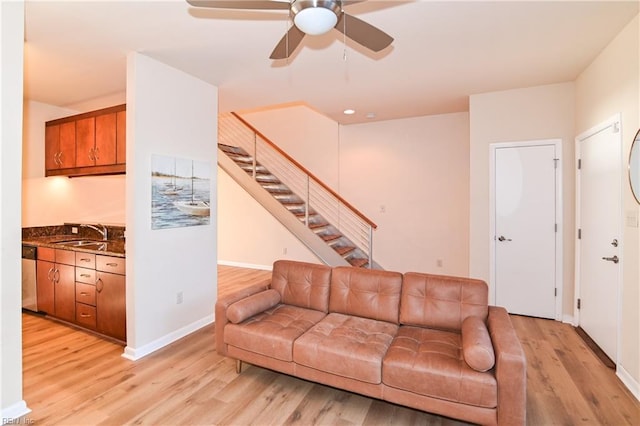 living room with ceiling fan, light hardwood / wood-style flooring, and sink