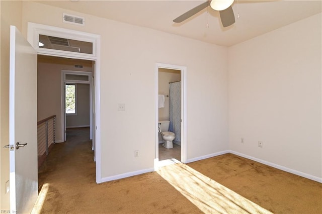 unfurnished bedroom featuring ensuite bathroom, ceiling fan, and light carpet