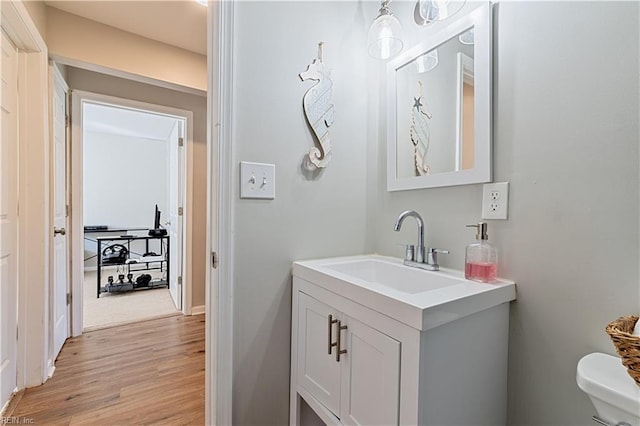 bathroom featuring hardwood / wood-style flooring, vanity, and toilet