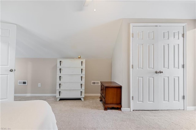 bedroom with light carpet, vaulted ceiling, a closet, and ceiling fan