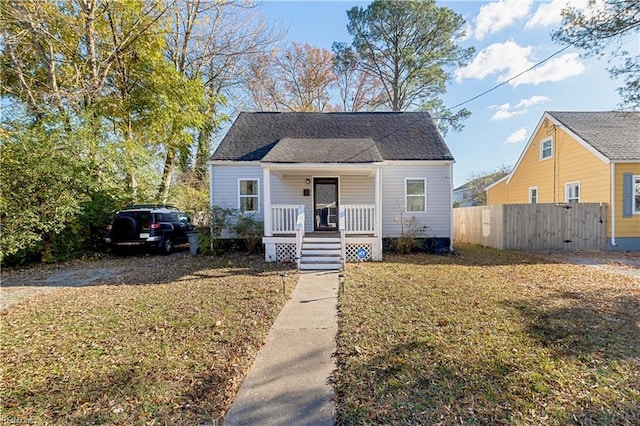 bungalow-style home featuring covered porch and a front yard