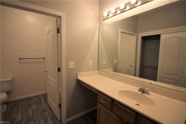 bathroom featuring toilet, vanity, and hardwood / wood-style flooring