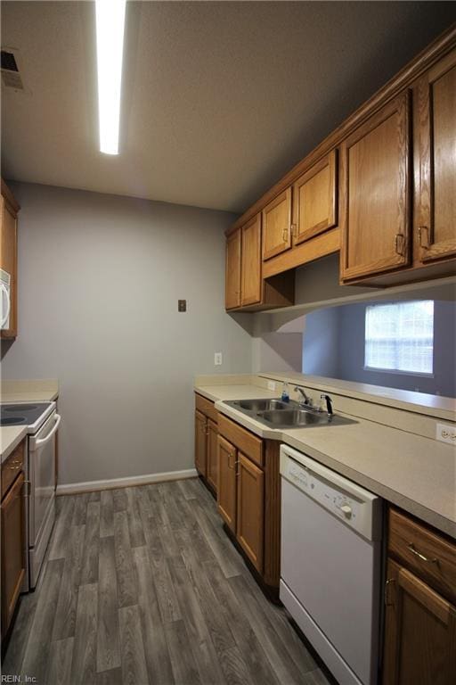 kitchen with dishwasher, stainless steel stove, dark hardwood / wood-style floors, and sink