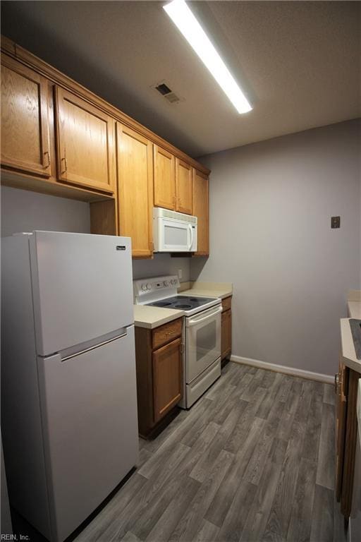 kitchen featuring dark hardwood / wood-style flooring and white appliances