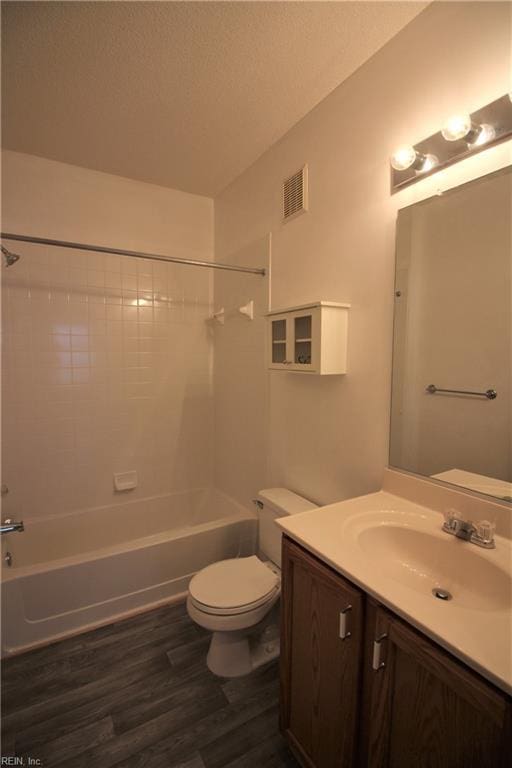 full bathroom with toilet, vanity, tiled shower / bath combo, and hardwood / wood-style flooring