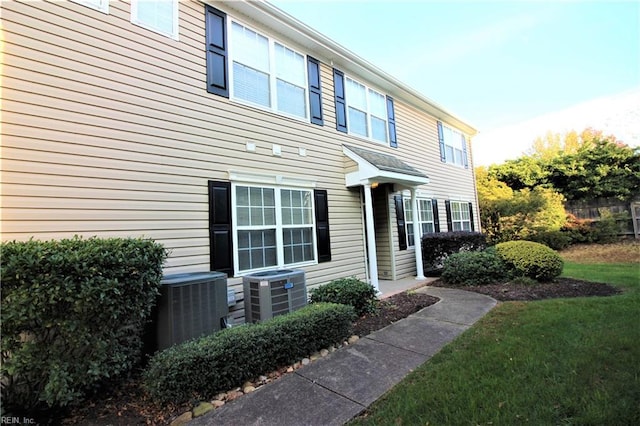 view of front of property with central air condition unit and a front lawn