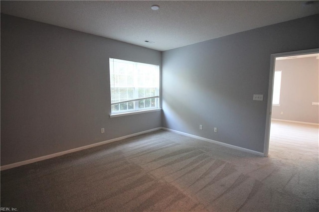 spare room with a textured ceiling and carpet floors