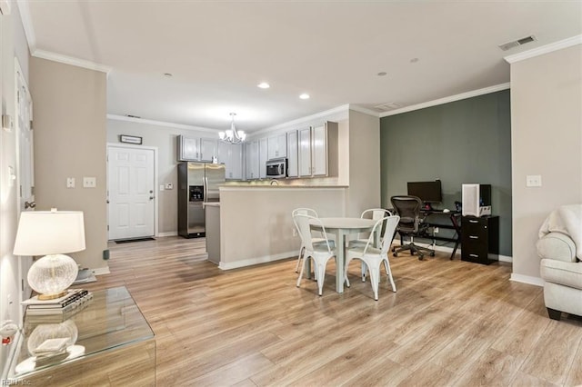 dining area with crown molding, light hardwood / wood-style floors, and a notable chandelier