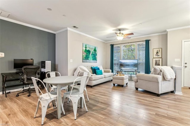 dining space featuring ceiling fan, light wood-type flooring, and crown molding