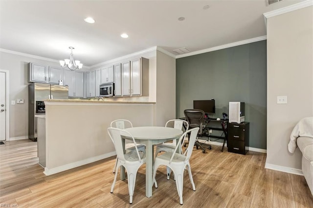 dining room featuring light hardwood / wood-style flooring, crown molding, and a notable chandelier