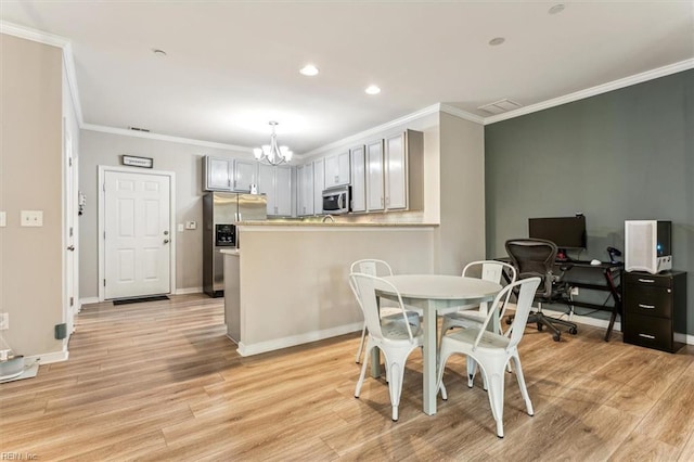 dining room with light wood-type flooring, an inviting chandelier, and ornamental molding