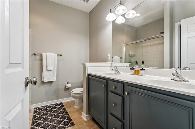 bathroom featuring tile patterned floors, vanity, toilet, and an enclosed shower