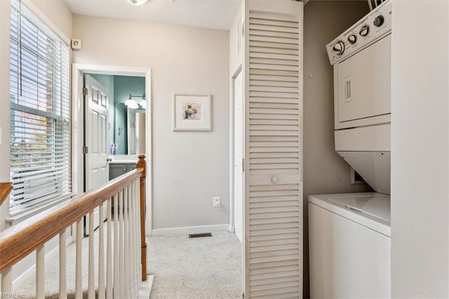 washroom featuring light carpet and stacked washer / drying machine