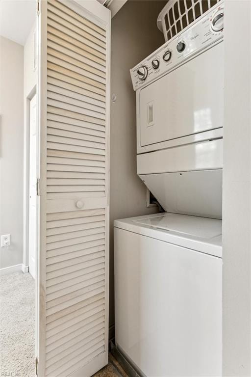 washroom featuring carpet flooring and stacked washer / drying machine