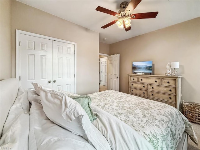 carpeted bedroom with ceiling fan and a closet