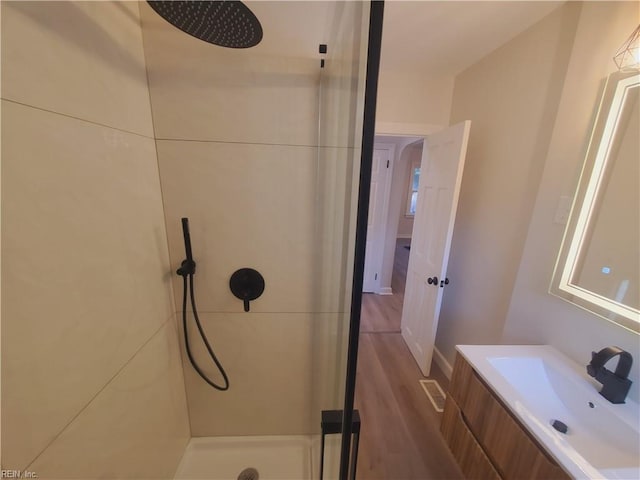 bathroom featuring a shower, hardwood / wood-style floors, and vanity