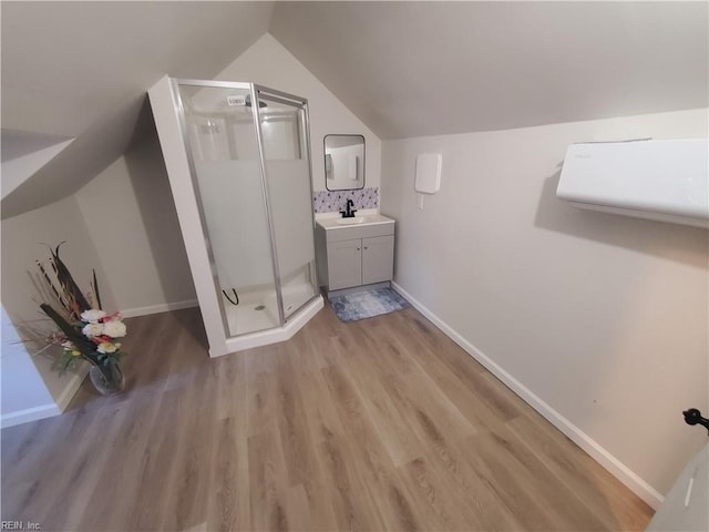 bathroom featuring hardwood / wood-style flooring, lofted ceiling, and a shower with door