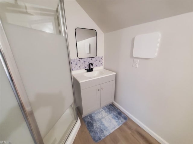 bathroom with hardwood / wood-style floors, vanity, and a shower with shower door