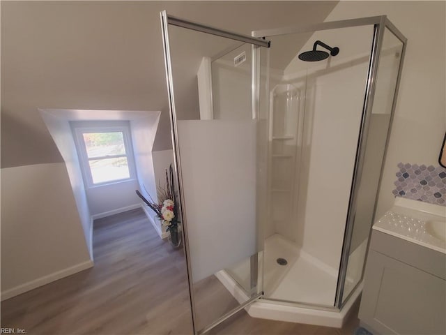 bathroom featuring hardwood / wood-style flooring, vanity, and a shower with shower door