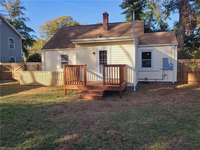 rear view of property with a deck and a yard