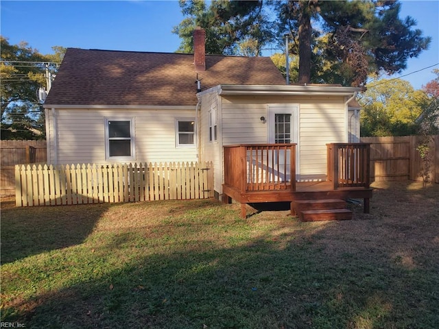 back of property featuring a lawn and a deck