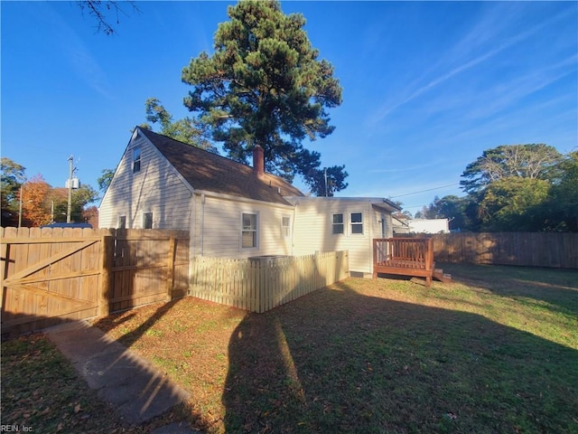 back of house with a lawn and a wooden deck