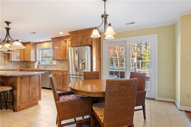 dining space with a chandelier, crown molding, a healthy amount of sunlight, and sink