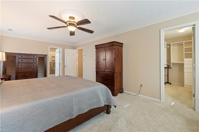 carpeted bedroom featuring ceiling fan, a closet, a spacious closet, and ornamental molding