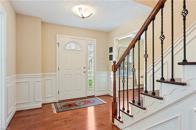 entrance foyer with hardwood / wood-style floors and a textured ceiling