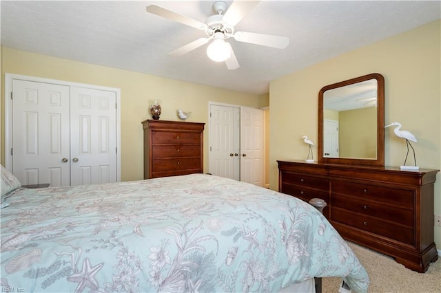 carpeted bedroom featuring ceiling fan and two closets