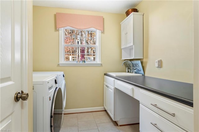 laundry room featuring light tile patterned flooring, washing machine and dryer, cabinets, and sink