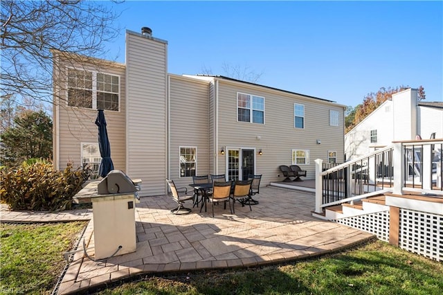 rear view of house featuring a patio area and a wooden deck