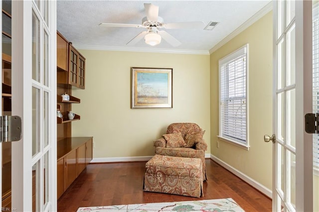 sitting room with dark hardwood / wood-style floors, ceiling fan, and crown molding