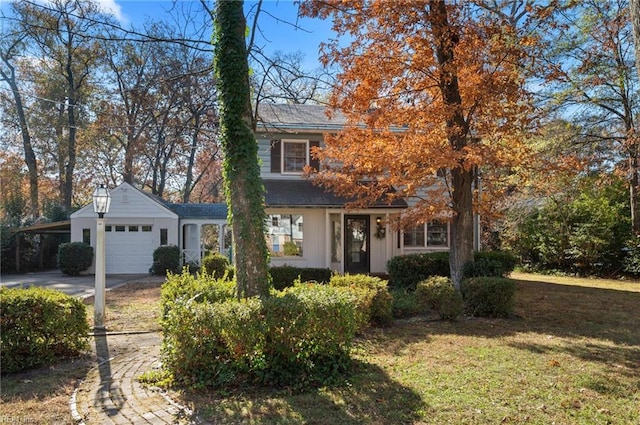 view of front facade with a front lawn, a garage, and a carport