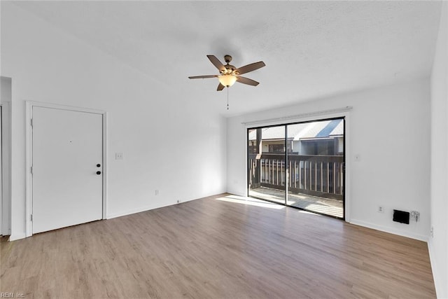 unfurnished room featuring a textured ceiling, ceiling fan, light hardwood / wood-style floors, and vaulted ceiling