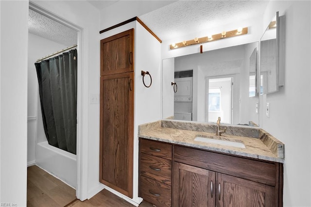 bathroom with hardwood / wood-style floors, vanity, a textured ceiling, and shower / tub combo with curtain